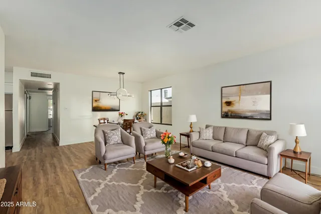 a living room with furniture a rug and a chandelier