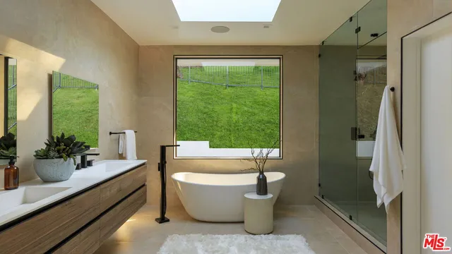 a bedroom with a bed and a large window with outer view