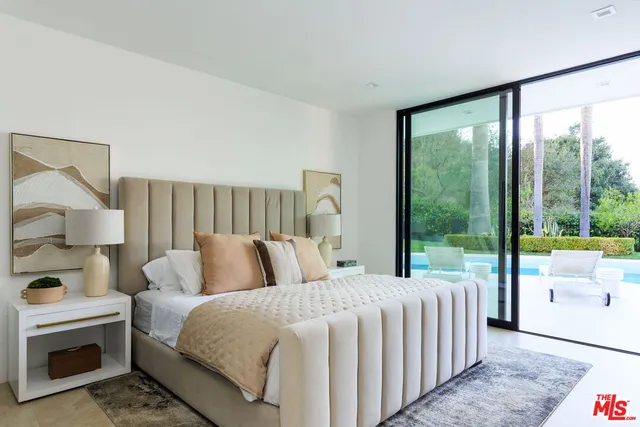 a bedroom with a bed and a large window