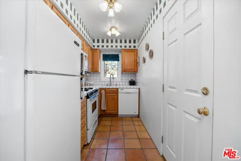 a kitchen with granite countertop a stove sink and cabinets