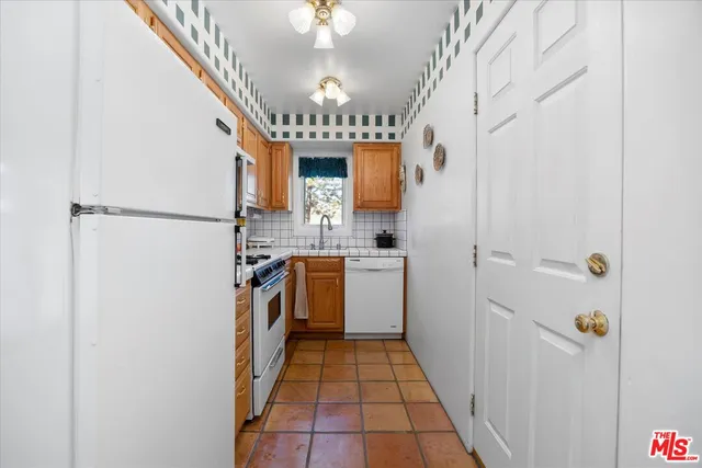 a kitchen with granite countertop a stove sink and cabinets