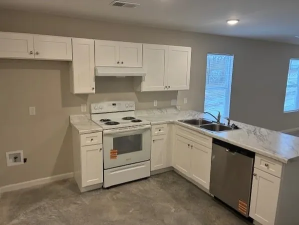 a kitchen with granite countertop white cabinets and white appliances