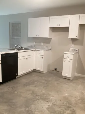 a room with granite countertop cabinets and sink