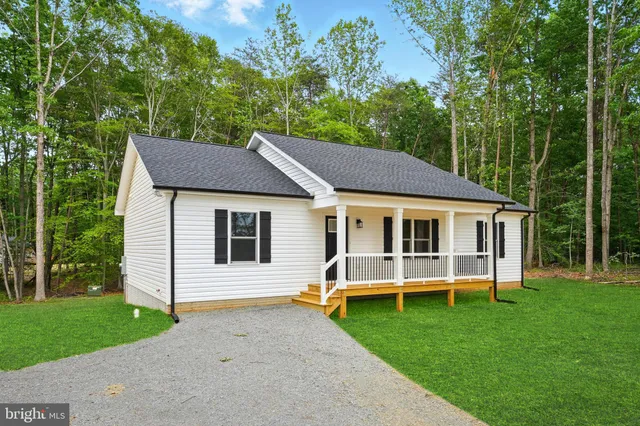 a aerial view of a house with a yard table and chairs