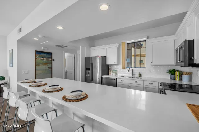 a bedroom with a large bed and a chandelier