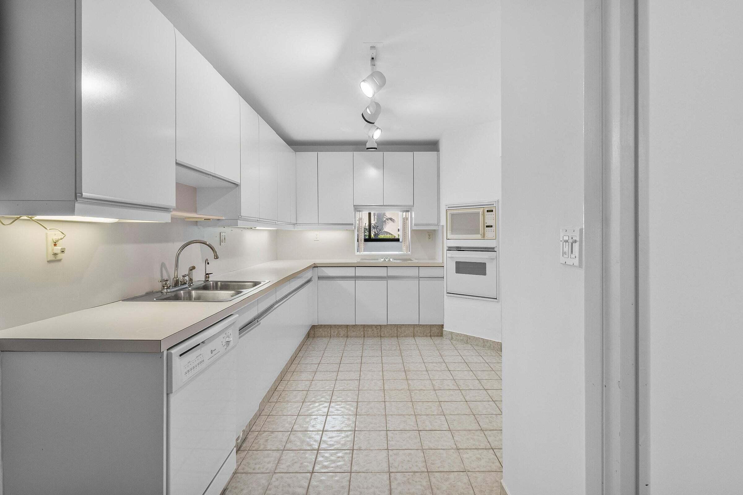 6711 North Ocean Boulevard, Unit 13 Ocean Ridge, FL 33435 - Photo 16 of 50 a kitchen with a sink cabinets and appliances