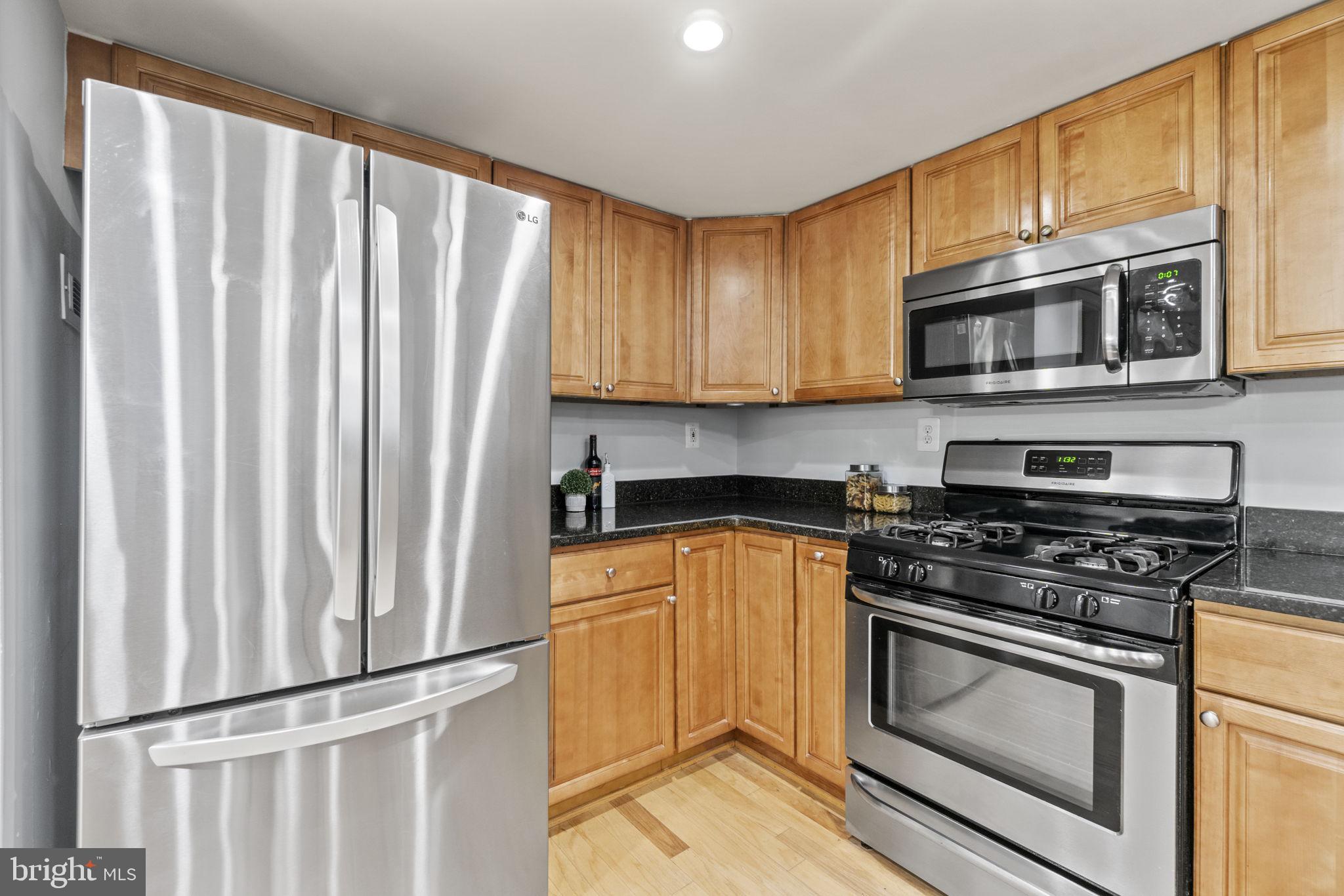 1515 South Arlington Ridge Road, Unit 603 Arlington, VA 22202 - Photo 5 of 22 a kitchen with stainless steel appliances wooden cabinets and a stove top oven