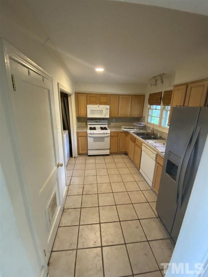 1418 Lyon Street Raleigh, NC 27608 - Photo 6 of 11 a kitchen with stainless steel appliances a refrigerator sink and microwave