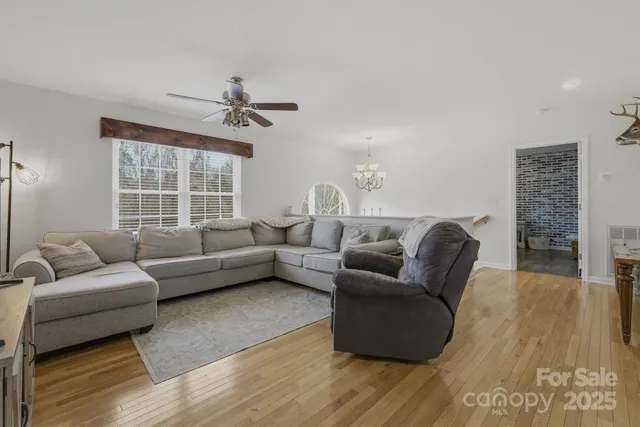 a kitchen with stainless steel appliances granite countertop a sink dishwasher stove refrigerator and microwave with wooden floor