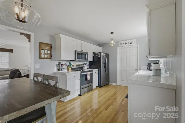 a kitchen with stainless steel appliances a stove refrigerator sink and microwave