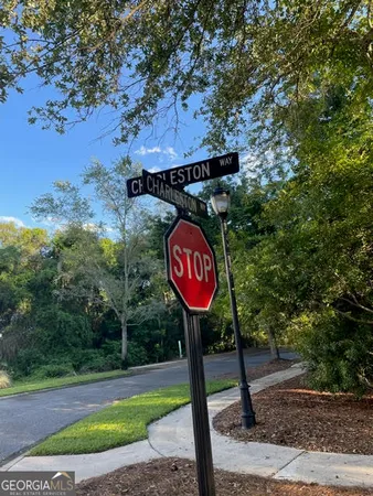 a view of a street sign under a large tree