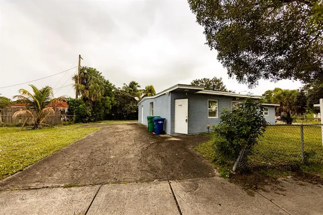 a view of a house with backyard and trees