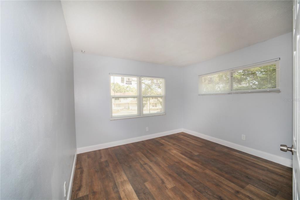 331 Amherst Avenue, Unit 56 Sarasota, FL 34232 - Photo 16 of 19 an empty room with wooden floor and windows