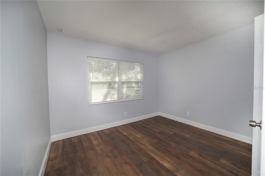 331 Amherst Avenue, Unit 56 Sarasota, FL 34232 - Photo 18 of 19 an empty room with wooden floor and windows