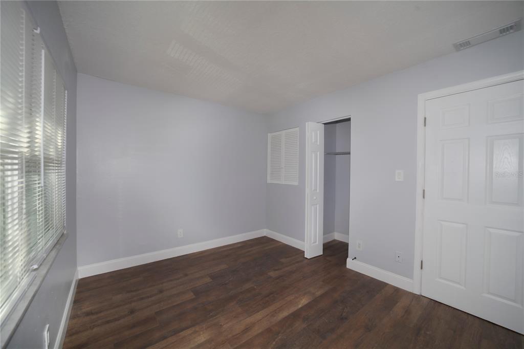 331 Amherst Avenue, Unit 56 Sarasota, FL 34232 - Photo 19 of 19 a view of an empty room with wooden floor and a window