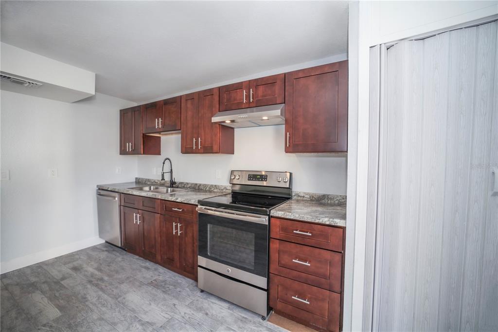 331 Amherst Avenue, Unit 56 Sarasota, FL 34232 - Photo 8 of 19 a kitchen with stainless steel appliances granite countertop a stove and a sink