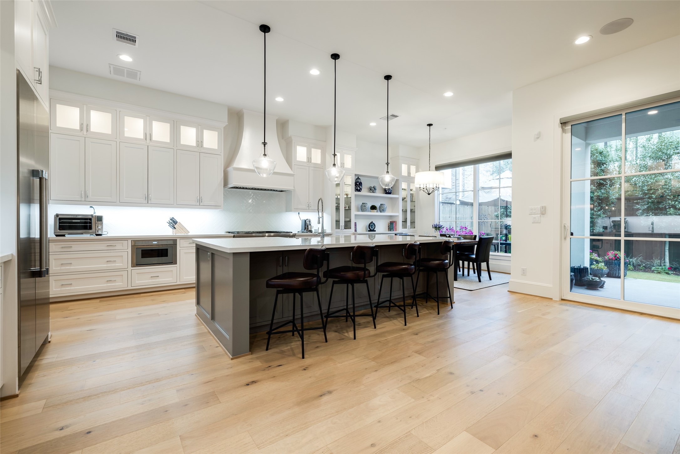 1918 Woodhead Street Houston, TX 77019 - Photo 22 of 49 a dining hall with stainless steel appliances kitchen island granite countertop a table chairs and a view of living room