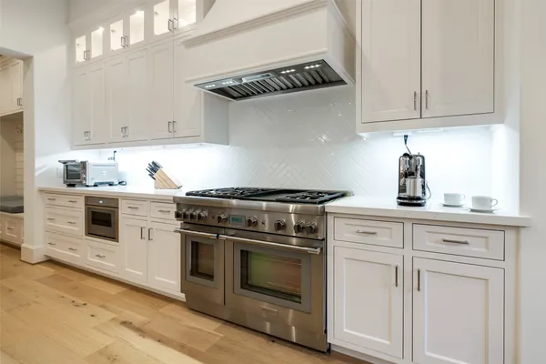 a kitchen with white cabinets and appliances