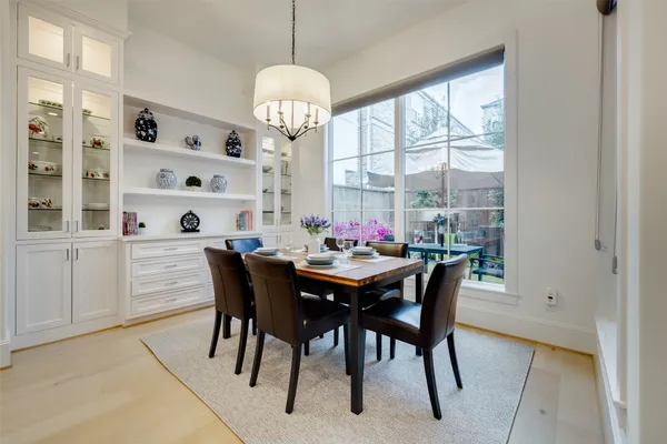 a view of a dining room with furniture a chandelier and wooden floor
