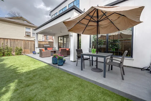 a view of a backyard with furniture and a umbrella
