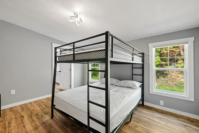 a bed sitting in a bedroom next to a window