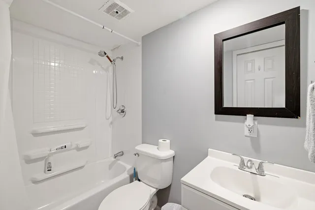 a bathroom with a toilet sink vanity and mirror