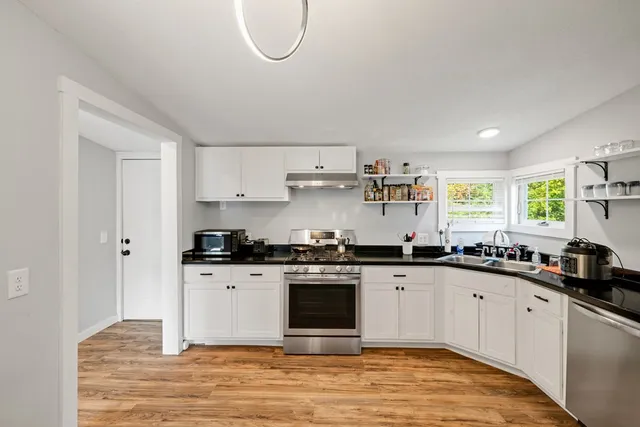a kitchen with stainless steel appliances granite countertop a stove a sink and a microwave