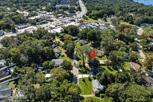 an aerial view of residential houses with outdoor space and trees