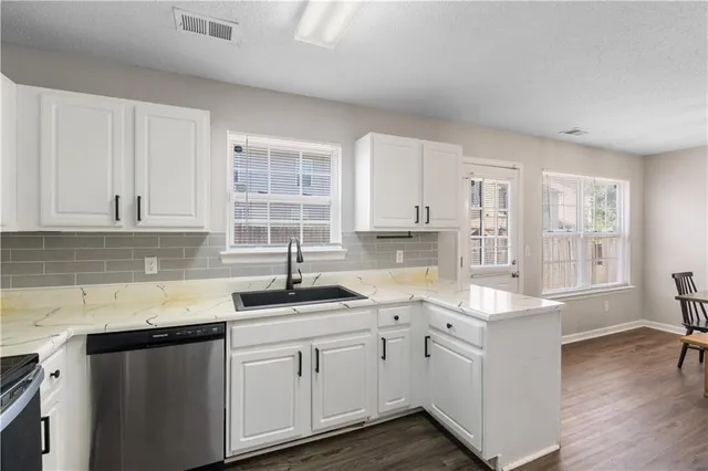 a kitchen with cabinets appliances a sink and a window
