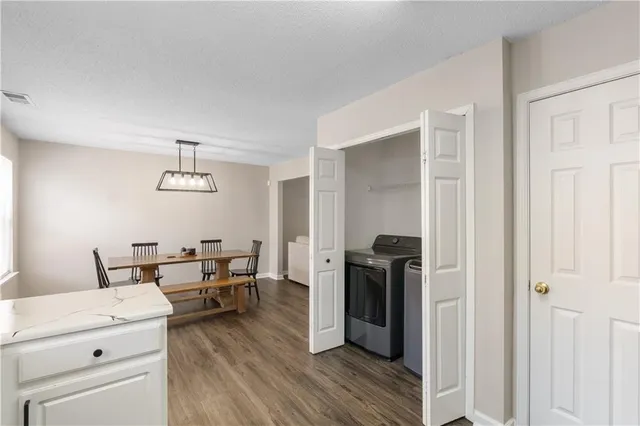 a kitchen with a refrigerator and wooden floor