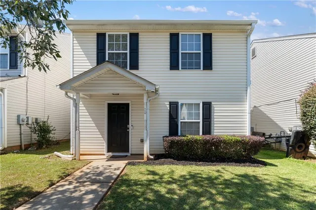 a view of a house with a yard and lawn chairs with a fire pit