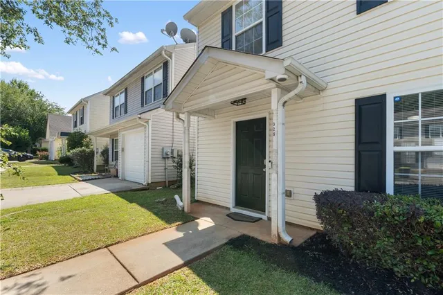 a view of a white house next to a yard