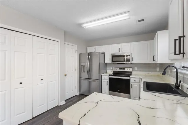 a kitchen with stainless steel appliances kitchen island granite countertop a refrigerator sink and stove