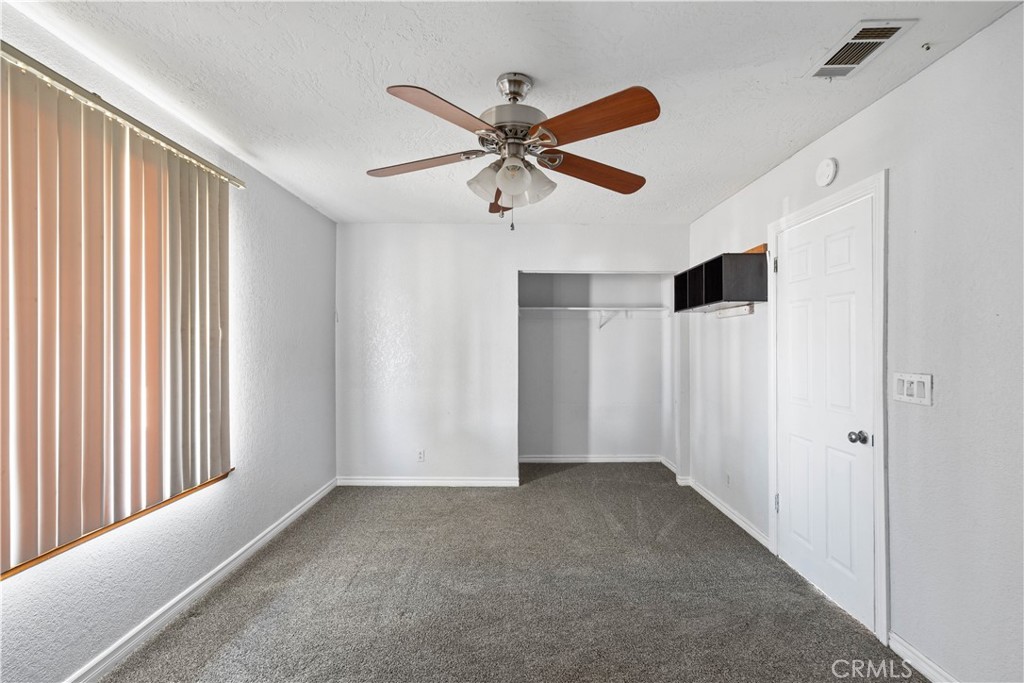 18891 Shoshonee Road Apple Valley, CA 92307 - Photo 13 of 33 a view of a livingroom with a ceiling fan & window