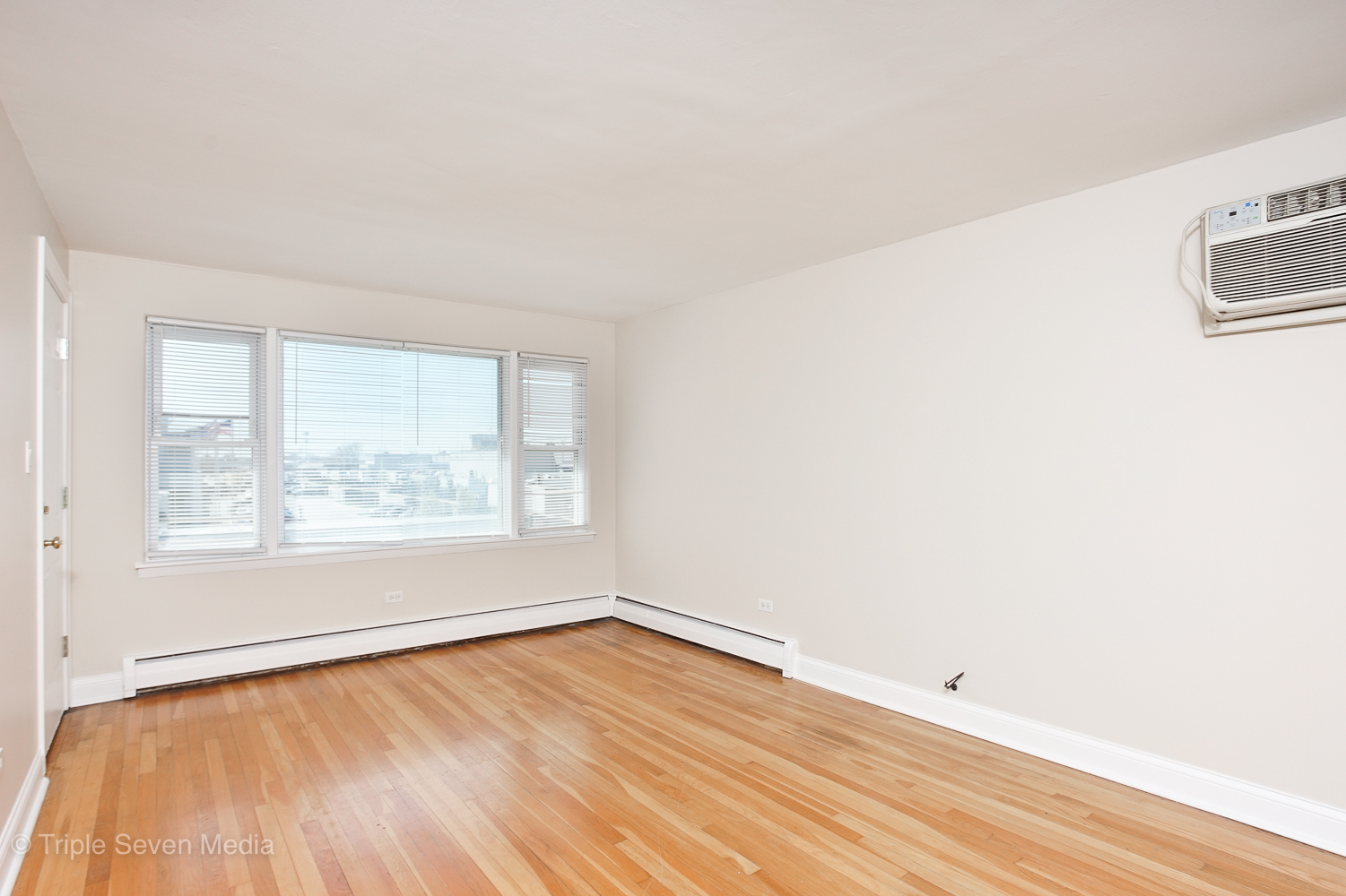 6952 West 65th Street, Unit 3C Chicago, IL 60638 - Photo 11 of 17 an empty room with wooden floor and windows