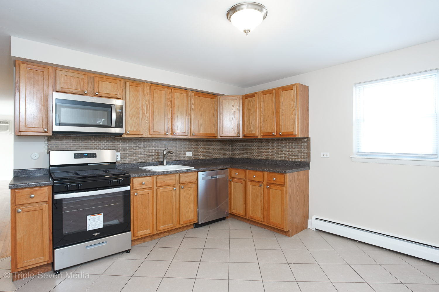 6952 West 65th Street, Unit 3C Chicago, IL 60638 - Photo 2 of 17 a kitchen with stainless steel appliances granite countertop a stove a sink and a microwave