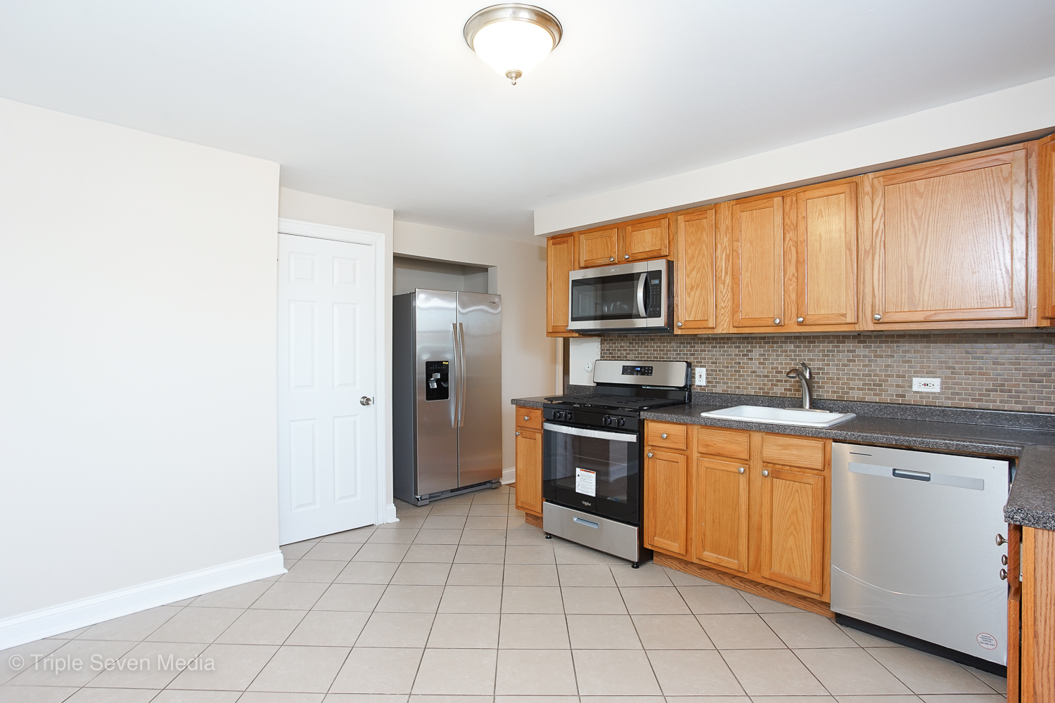 6952 West 65th Street, Unit 3C Chicago, IL 60638 - Photo 3 of 17 a kitchen with stainless steel appliances granite countertop a stove top oven a sink dishwasher and a refrigerator