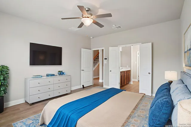 a bedroom with a bed a window and a flat screen television