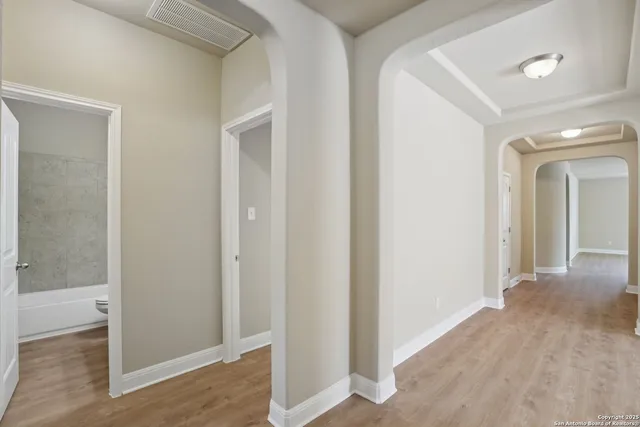 a view of a hallway with wooden floor