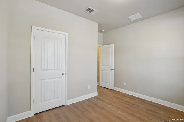 a view of an empty room with wooden floor