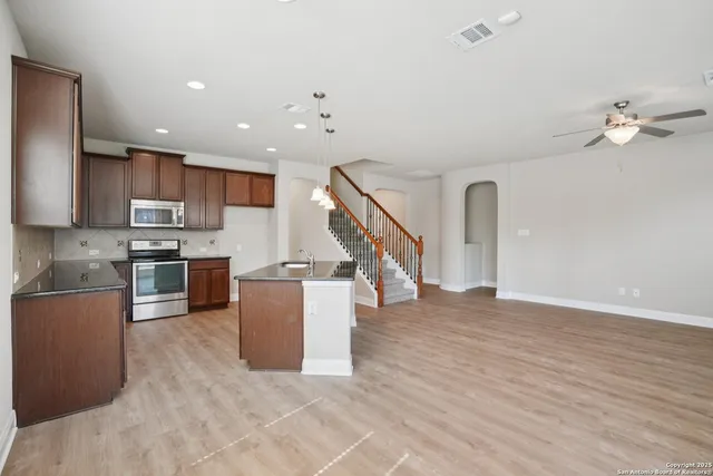 a kitchen with a refrigerator and a stove top oven