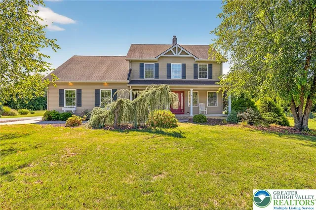 a front view of a house with yard and swimming pool