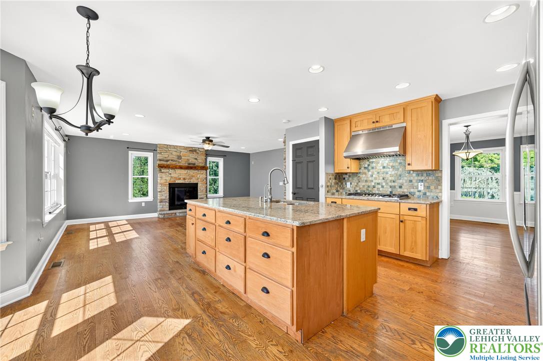 202 Cherry Court Nazareth, PA 18064 - Photo 15 of 43 a large kitchen with kitchen island granite countertop a stove a sink a refrigerator and white cabinets with wooden floor