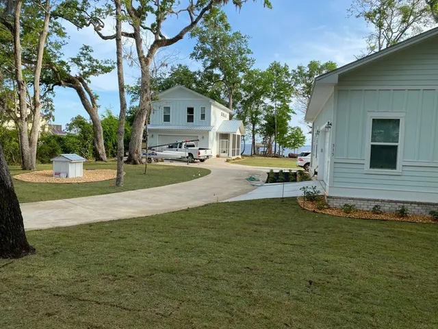 a front view of a house with yard and green space