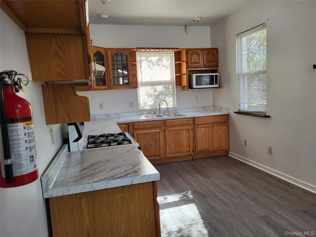 a kitchen with stainless steel appliances granite countertop sink stove top oven and cabinets