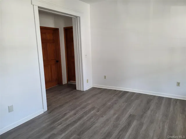 an empty room with wooden floor and closet