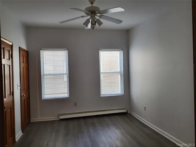 an empty room with a window and a ceiling fan