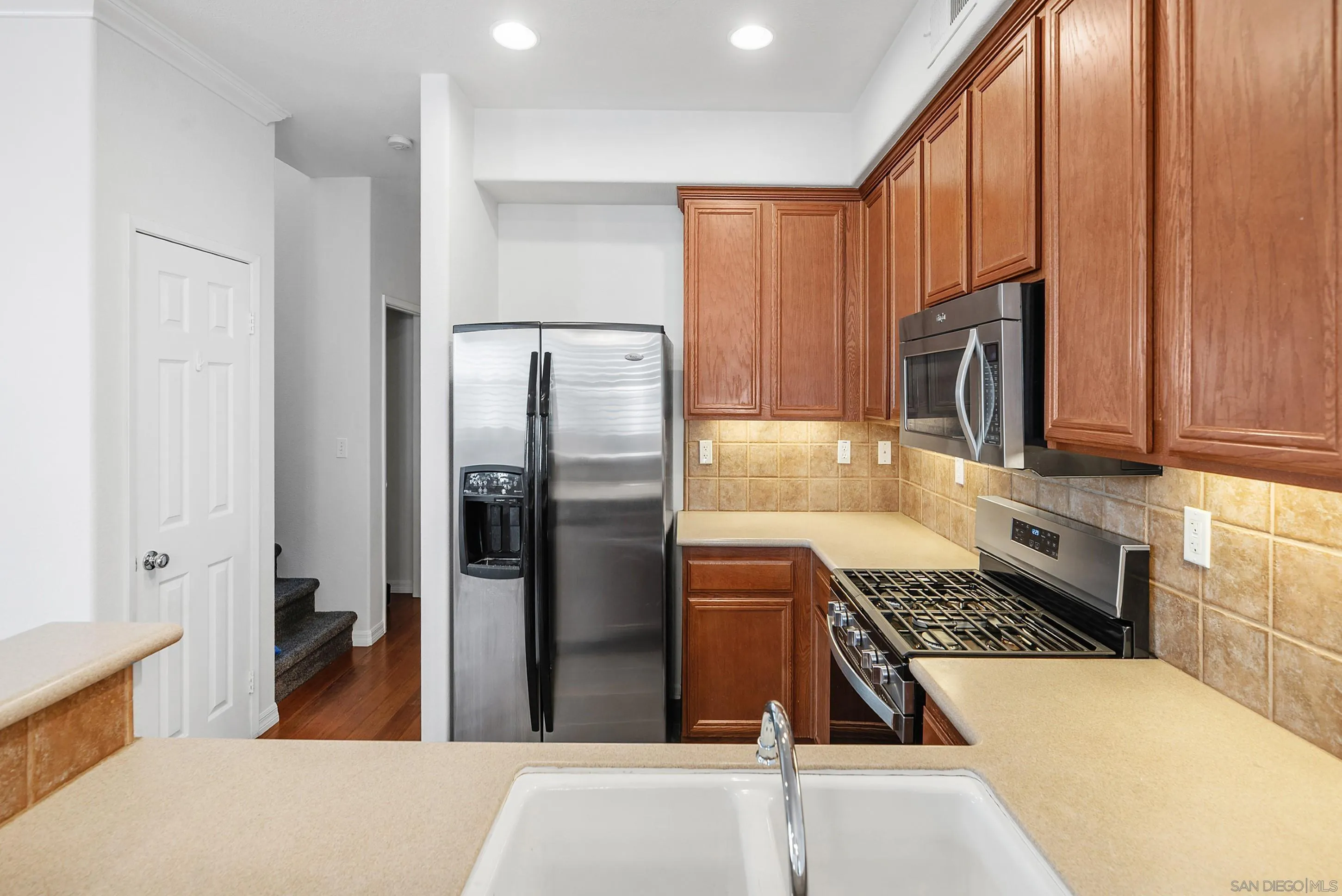 2185 Caminito Rinaldo, Unit 118 Chula Vista, CA 91915 - Photo 11 of 38 a kitchen with stainless steel appliances granite countertop a refrigerator and a stove top oven