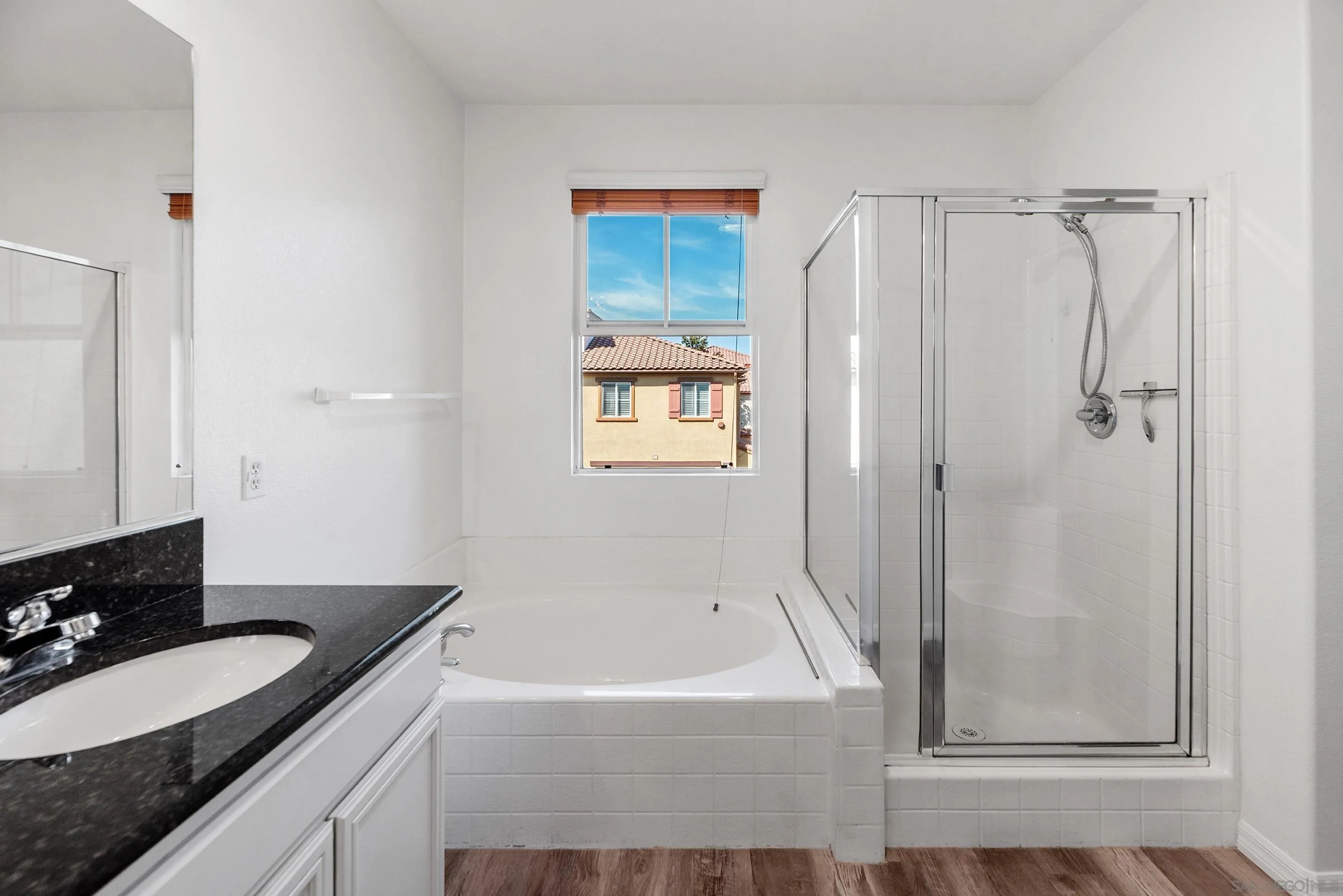 2185 Caminito Rinaldo, Unit 118 Chula Vista, CA 91915 - Photo 16 of 38 a bathroom with a granite countertop bathtub shower sink vanity and mirror
