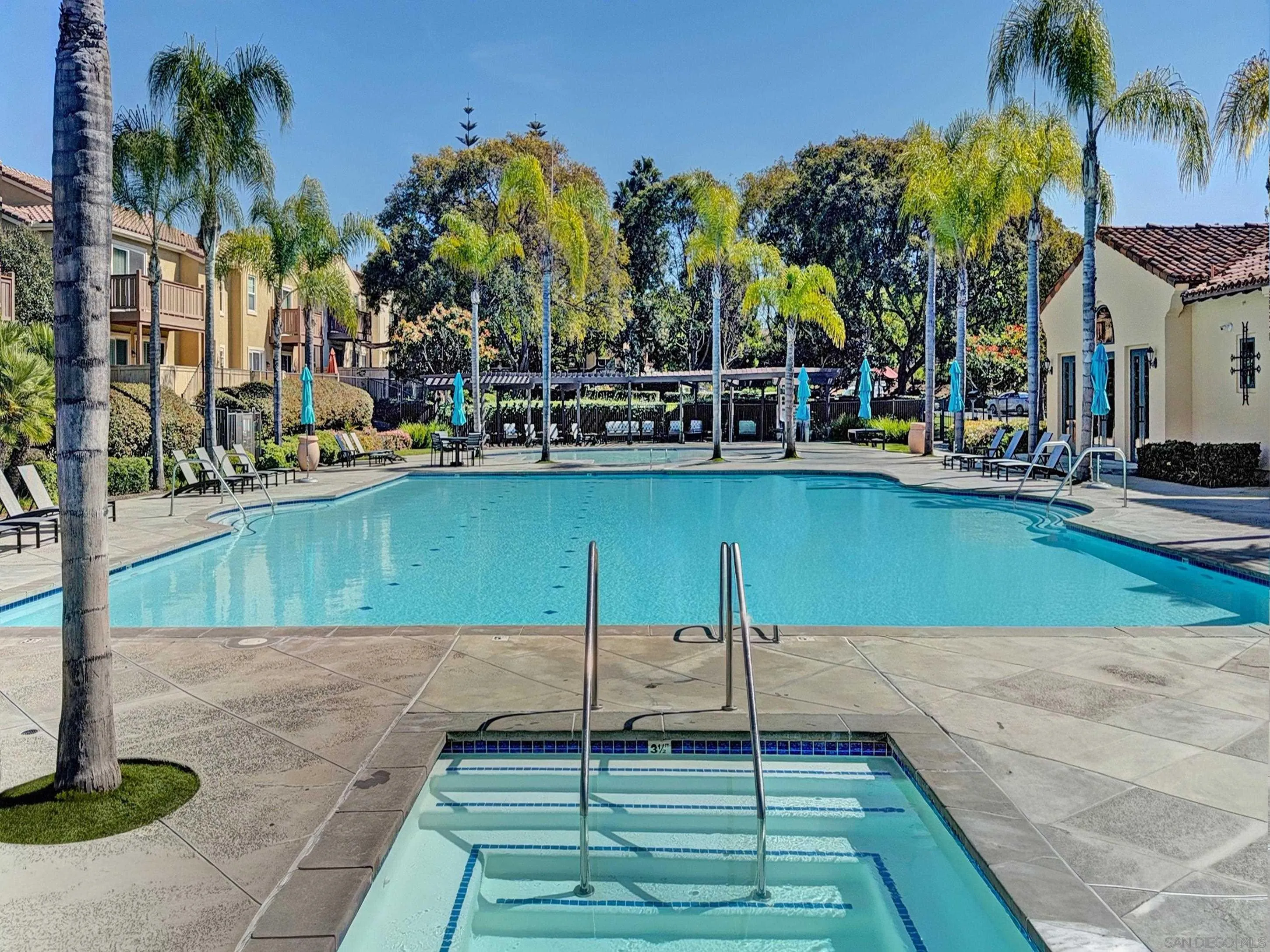 2185 Caminito Rinaldo, Unit 118 Chula Vista, CA 91915 - Photo 30 of 38 a view of a swimming pool with a lawn chairs under palm trees